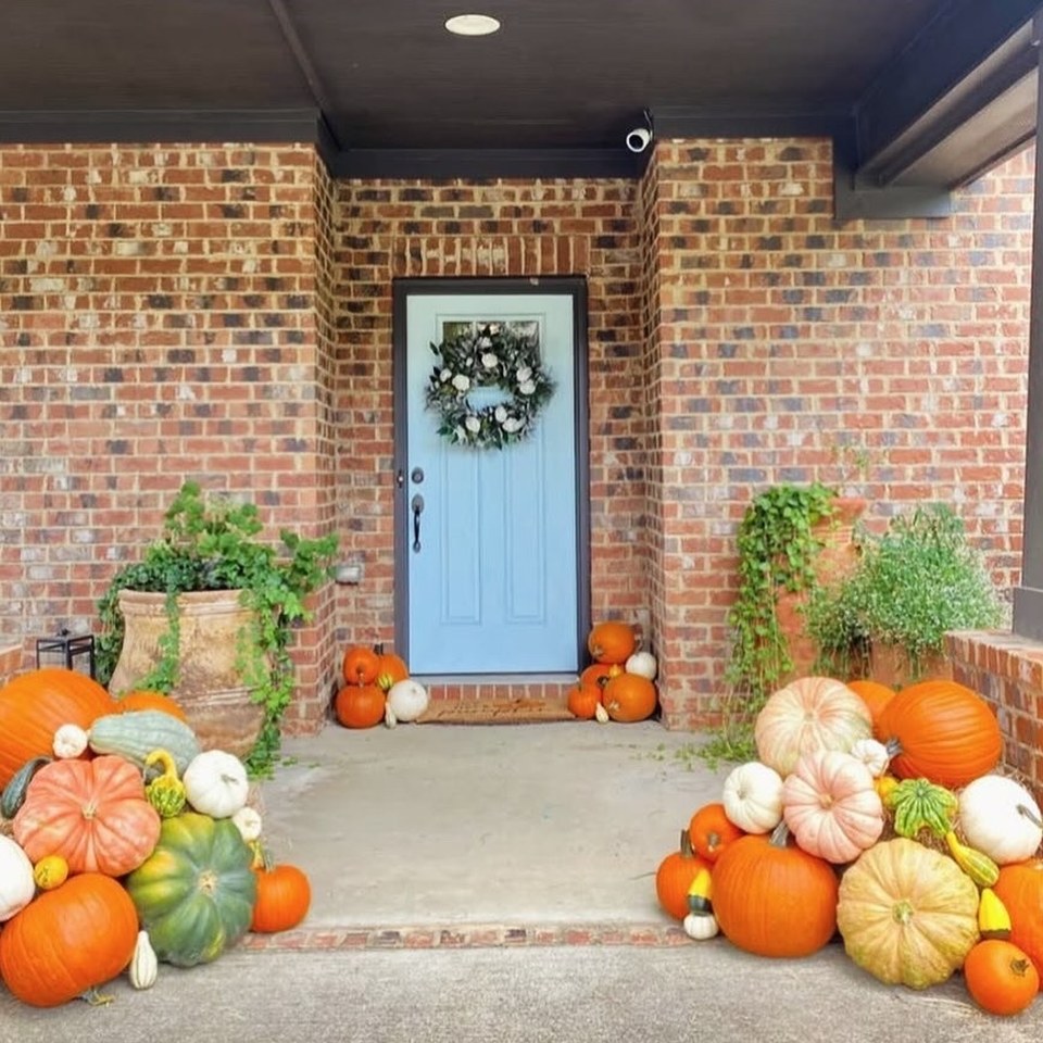 After: the same red brick porch styled with heirloom pumpkins and gourds by Front Porch Collective