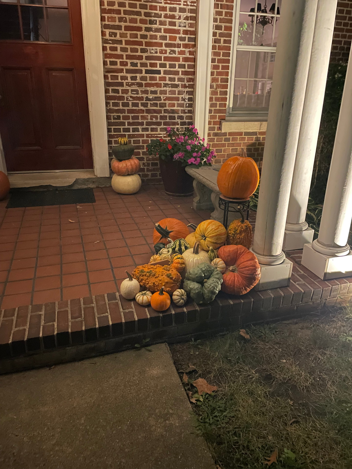 Traditional brick front porch in Des Moines styled with heirloom pumpkins, gourds, and natural fall texture